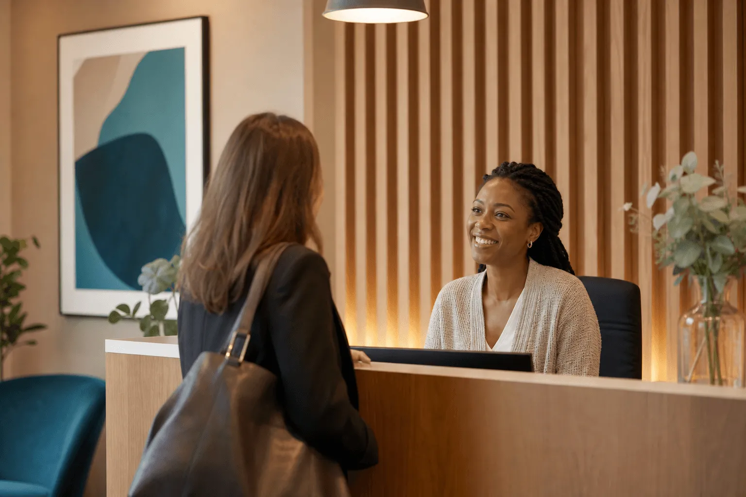A warm clinic reception where a receptionist welcomes a new client.