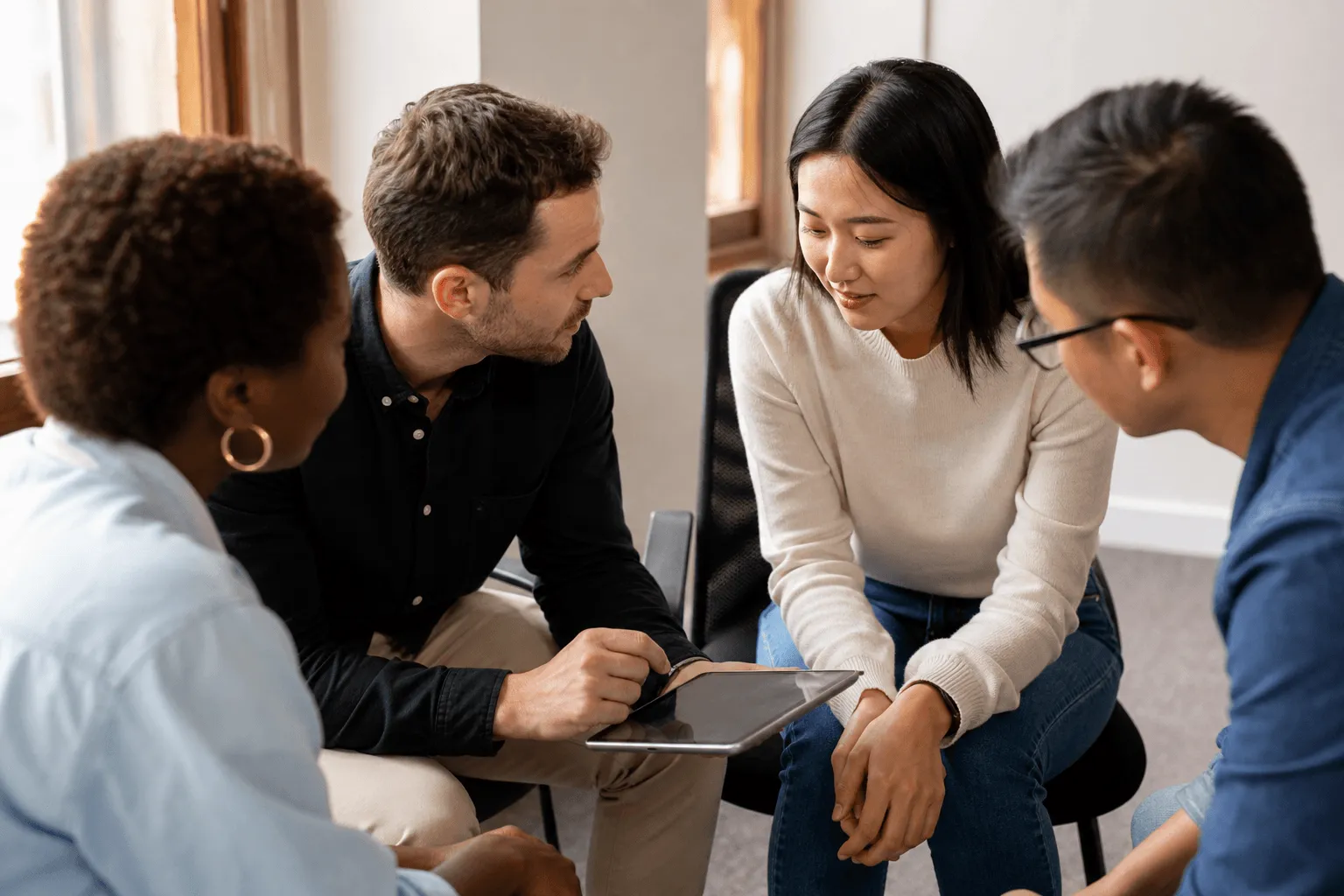 A facilitator coaching a participant during a small-group neurodiversity training session.